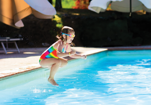 Young girl jumping in the pool